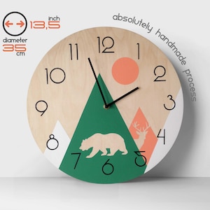 Mountain and forest themed wall clock for nursery or cabin decor. Minimalist wooden wall art with bear and deer silhouettes in green and orange. Scandinavian style kids' room clock featuring natural wood finish and clear black numbers for easy reading.