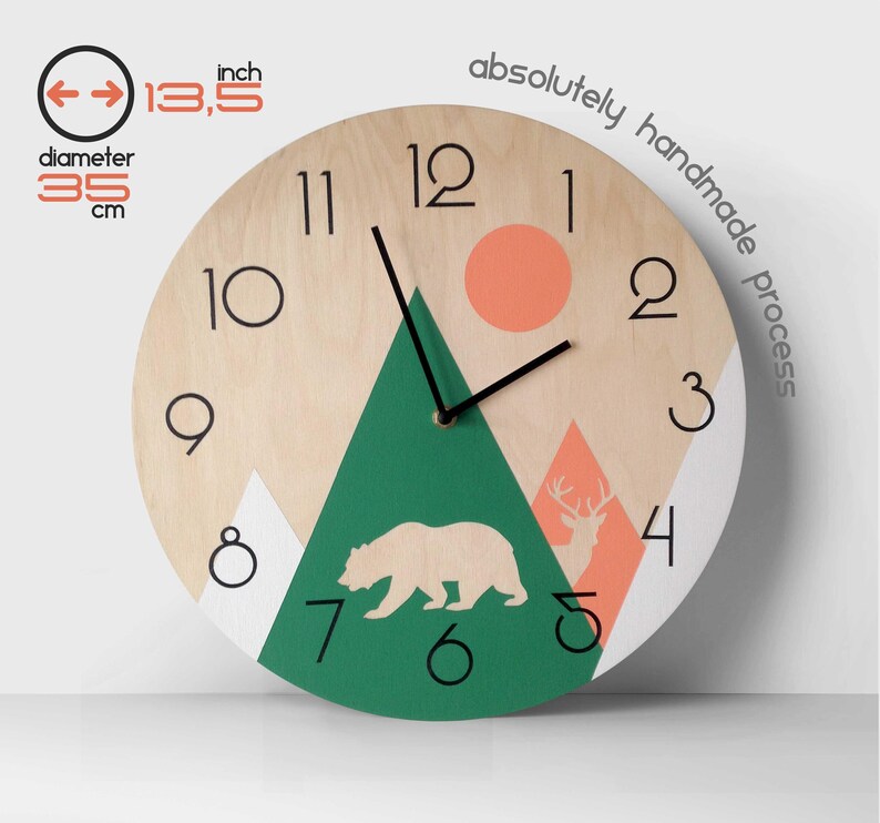 Mountain and forest themed wall clock for nursery or cabin decor. Minimalist wooden wall art with bear and deer silhouettes in green and orange. Scandinavian style kids' room clock featuring natural wood finish and clear black numbers for easy reading.