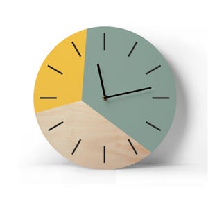 Könnte beinhalten: Eine runde Holzuhr mit einem gelben, grünen und naturfarbenen Zifferblatt. Die Uhr hat schwarze Zeiger und schwarze Stundenmarkierungen.