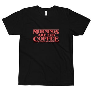 Op de afbeelding: Zwart T-shirt met rode tekst die "Mornings are for Coffee & Contemplation" zegt.