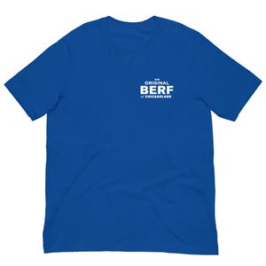 May include: A royal blue short-sleeved t-shirt featuring white text on the upper left chest that reads THE ORIGINAL BERF of CHICAGOLAND. The garment has a crew neckline and a standard fit, showcasing a solid color design throughout the fabric.