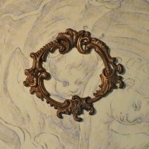May include: A decorative metal frame with an ornate design. The frame is made of brass and has a gold finish. It is a vintage style frame with a delicate and intricate design.