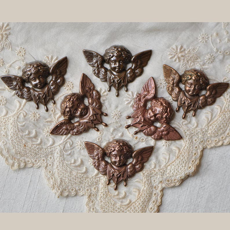 May include: Six antique-style metal cherub figurines with wings and a distressed bronze finish. Each cherub has a sweet, innocent expression and is adorned with delicate details.