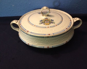 May include: White porcelain serving dish with a lid. The dish has a floral design with blue, red, and yellow accents. The lid has a gold knob.