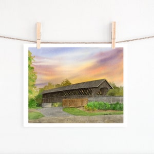 May include: Watercolour painting of a covered bridge at sunset. The bridge is brown with a lattice design, set against a colourful sky of orange, purple, and blue. Green trees and foliage surround the bridge, with a grey road in the foreground.