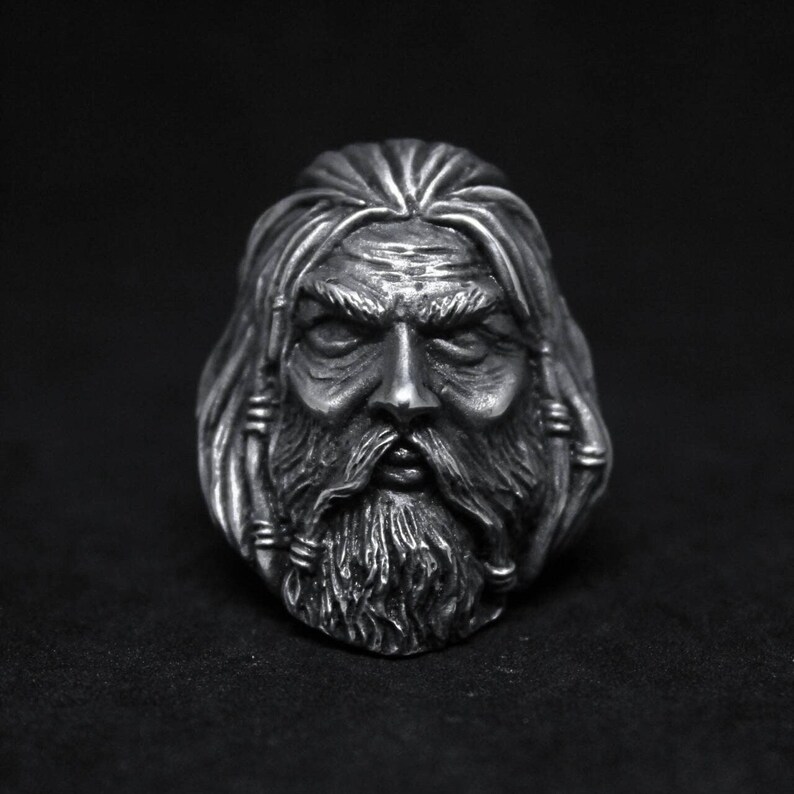 Puede incluir: Un anillo de plata con una escultura detallada de la cara de un hombre barbudo. El hombre tiene el pelo largo y una expresi&oacute;n seria.
