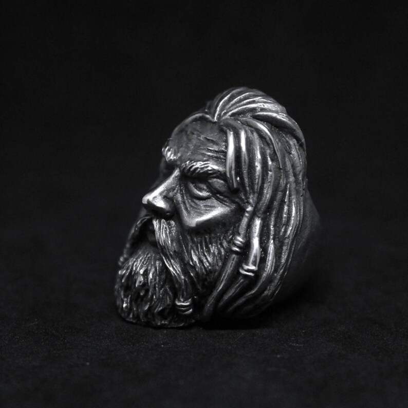Puede incluir: Un anillo de plata con una escultura detallada de la cara de un hombre con el pelo largo y barba.