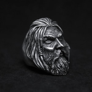 Puede incluir: Un anillo de plata con un dise&ntilde;o detallado de la cara de un hombre con el pelo largo y barba.