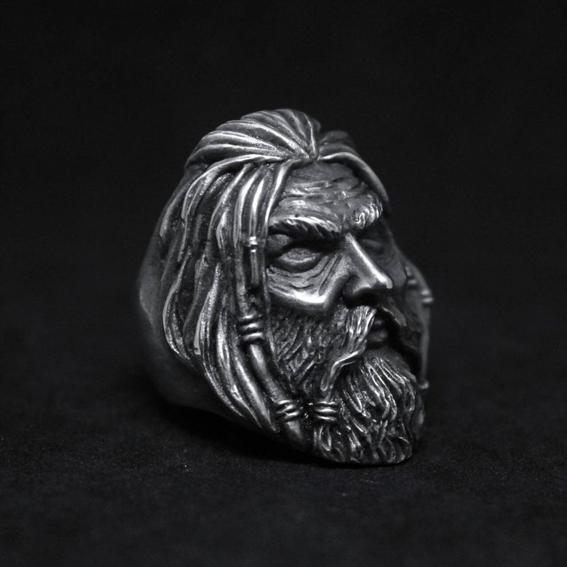 Puede incluir: Un anillo de plata con un dise&ntilde;o detallado de la cara de un hombre con el pelo largo y barba.