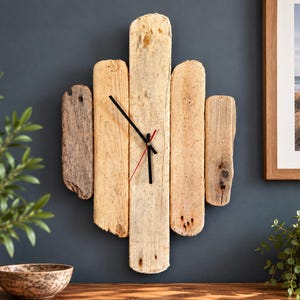 May include: A wall clock constructed from five vertical pieces of weathered driftwood arranged in a staggered pattern. The clock features simple black hour and minute hands and a thin red second hand centred on the light tan wooden planks.