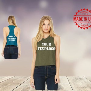 May include: Two women's tank tops, one teal and one olive green, with the text "YOUR DESIGN HERE" and "YOUR TEXT/LOGO" printed on them. The tops are cropped and have a racerback style.