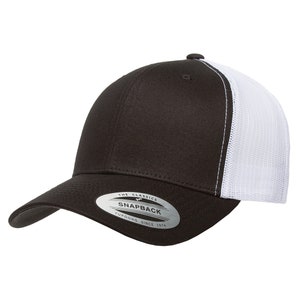 Puede incluir: Una gorra de b&eacute;isbol negra y blanca con una parte trasera de malla. La gorra tiene un panel frontal negro y un panel trasero de malla blanca. La gorra tiene una pegatina en la parte delantera que dice "The Classics Yupoong Snapback Since 1974".