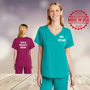 May include: Two women wearing teal and burgundy scrubs with white text that says "Your Design Here" and "Your Text/Logo". The image also includes a red stamp that says "Handmade Made in USA Original".