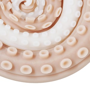 May include: Close-up of a light brown rubber octopus suction cup with multiple rows of suction cups.