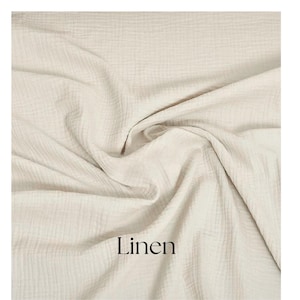May include: Cream-colored linen fabric with a textured, crinkled appearance. The fabric is draped and folded, creating soft shadows and highlights. The word "Linen" is printed in black at the bottom of the image.