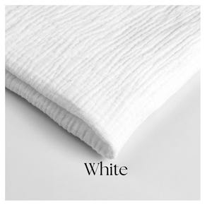 May include: A folded white fabric with a textured, crinkled surface. The word "White" is displayed in a simple font at the bottom of the image. The fabric appears soft and possibly made of cotton or a similar material.