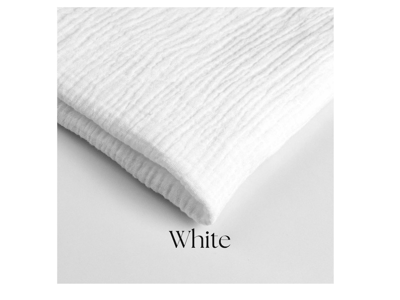 May include: A folded white fabric with a textured, crinkled surface. The word "White" is displayed in a simple font at the bottom of the image. The fabric appears soft and possibly made of cotton or a similar material.