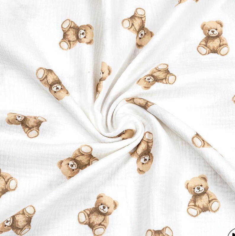 May include: White fabric with a repeating pattern of brown teddy bears. The bears are in various poses, some sitting and others lying down. The fabric has a soft, textured appearance.