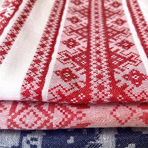 Könnte beinhalten: Drei gefaltete Küchentücher mit roten und weißen geometrischen Mustern. Das obere Handtuch hat ein rotes und weißes geometrisches Muster, das mittlere Handtuch hat ein rotes und weißes Blumenmuster und das untere Handtuch hat ein blaues und weißes geometrisches Muster.