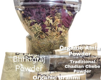 Peut inclure: Quatre petits sachets de différentes poudres à base de plantes. Les sachets sont étiquetés "Poudre d'Amla Bio", "Poudre de Chebe Tchadienne Traditionnelle", "Poudre de Brahmi Bio" et "Poudre de Bhringraj".