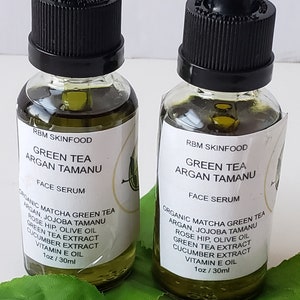 Puede incluir: Dos frascos de 30 ml de suero facial de t&eacute; verde, arg&aacute;n y tamanu. Los frascos son de vidrio transparente con goteros negros y etiquetas blancas. Las etiquetas tienen el texto "RBM SkinFood", "Green Tea Argan Tamanu", "Face Serum", y una lista de ingredientes que incluyen t&eacute; verde matcha, arg&aacute;n, tamanu de jojoba, rosa mosqueta, aceite de oliva, extracto de t&eacute; verde, extracto de pepino y vitamina E.