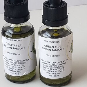 Puede incluir: Dos botellas de 30 ml de suero facial de t&eacute; verde, arg&aacute;n y tamanu. Las botellas son de vidrio transparente con goteros negros y etiquetas blancas. Las etiquetas tienen el texto "RBM SkinFood Green Tea Argan Tamanu Face Serum" y enumeran los ingredientes: "T&eacute; verde matcha org&aacute;nico, arg&aacute;n, tamanu de jojoba, rosa mosqueta, aceite de oliva, extracto de t&eacute; verde, extracto de pepino, aceite de vitamina E".