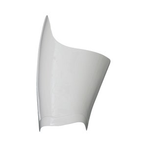 Puede incluir: Objeto de plástico blanco curvado, con un acabado liso y brillante. El diseño presenta una parte superior puntiaguda y una forma redondeada y abierta, lo que sugiere una función protectora o decorativa. El objeto está sobre un fondo blanco liso.