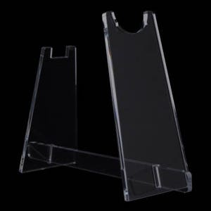 May include: Transparent acrylic display stand. The stand has a simple design with a vertical back and a curved top, plus a horizontal base. It's suitable for displaying collectibles. The clear material ensures the displayed item is easily visible.