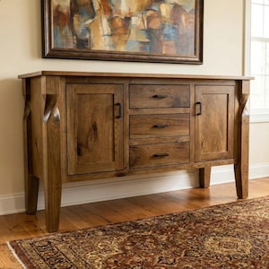 May include: A wooden sideboard featuring a natural brown finish, two side cabinets with vertical doors, and three central stacked drawers. Each drawer and cabinet door is equipped with a simple, dark rectangular metal handle pull.