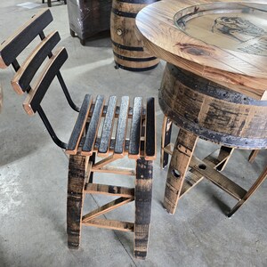 May include: A set of rustic bar furniture made from reclaimed wood. The set includes a bar stool with a slatted seat and back, and a round bar table. The wood has a natural finish with dark accents.