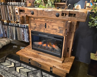 May include: A rustic wooden fireplace mantel with a built-in electric fireplace. The mantel is made of reclaimed wood and has a distressed finish. The fireplace has a black metal surround and a realistic flame effect.