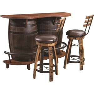 May include: A wooden bar set with two barrel-shaped stools and a bar top made from reclaimed wood. The bar top is supported by two barrels and has a metal footrest. The stools have a metal frame and a brown leather seat.