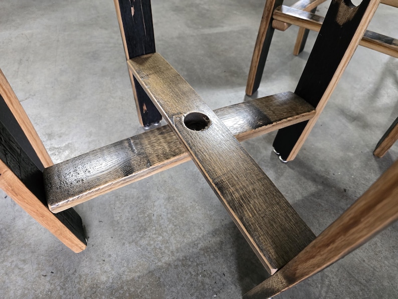 May include: Close-up of a wooden chair with a rustic design. The chair features a dark stained frame with a natural wood seat and back. The chair is made from reclaimed wood and has a unique, handcrafted appearance.