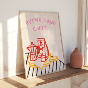 May include: A framed illustration of a coffee pot, coffee bag, and a cup on a striped background. The text "BUONGIORNO CAFFE" is written in pink letters at the top of the frame.