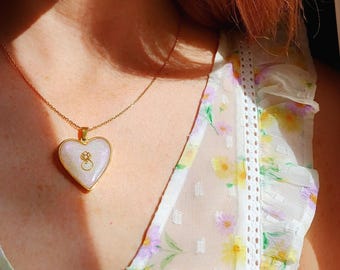 Collar de oro con colgante de corazón y flor de loto de resina.