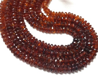 May include: Strands of faceted, reddish-brown gemstone beads. The beads are small and uniform in size, creating a textured, layered effect. The color varies slightly, with some beads appearing darker than others. The beads are strung together, forming a necklace or bracelet.