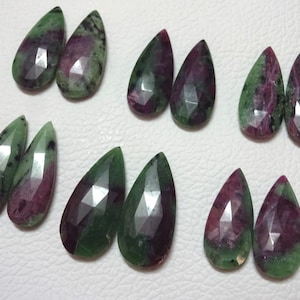 May include: Twelve green and pink gemstone pear-shaped drops. The gemstones have a faceted cut and are arranged in pairs.