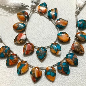 May include: A strand of turquoise and orange gemstone beads, with a teardrop shape, strung on silver wire. The beads are a mix of turquoise, orange, and white.