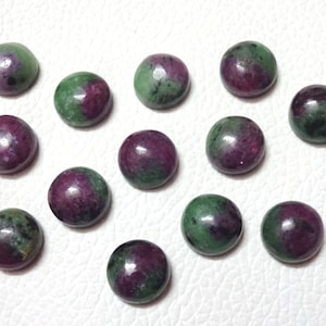 Puede incluir: Una colección de 13 cabujones redondos de piedra preciosa verde y rosa. Los cabujones son lisos y pulidos.