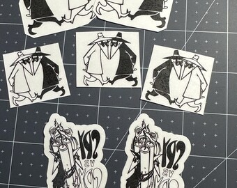 May include: Black and white stickers featuring the Spy vs. Spy characters from Mad Magazine. The stickers depict the characters in various poses, along with stickers that say "192" and "2v".