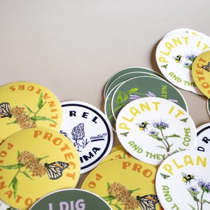 May include: A collection of round stickers with nature-themed designs. Some stickers are yellow with a butterfly and the text "PROTECT POLLINATORS". Others are green with floral illustrations and the text "I DIG NATIVE PLANTS".