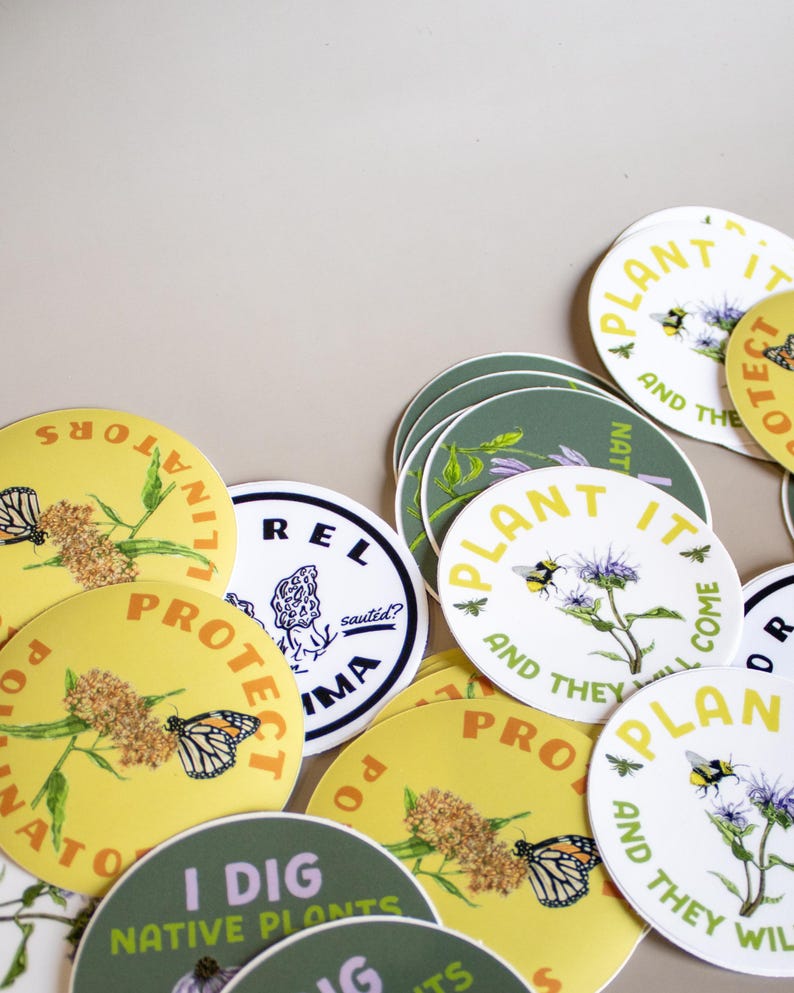 May include: A collection of round stickers with nature-themed designs. Some stickers are yellow with a butterfly and the text "PROTECT POLLINATORS". Others are green with floral illustrations and the text "I DIG NATIVE PLANTS".