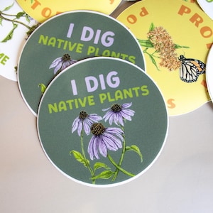 May include: Round stickers with the text "I DIG NATIVE PLANTS" and illustrations of purple coneflowers. Other stickers feature butterflies and text on a yellow background. The stickers have a white border.
