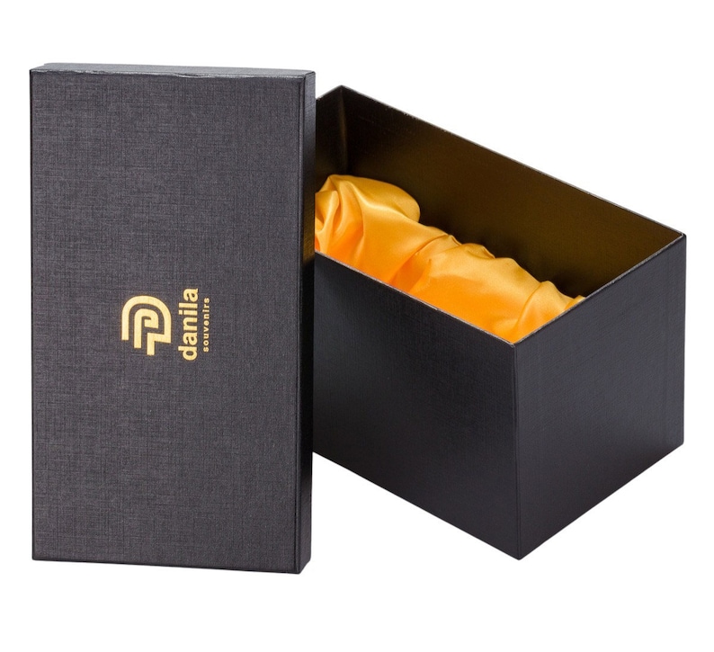 May include: Black gift box with a gold logo that says "danila souvenirs". The box is open and lined with yellow satin.