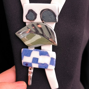 Puede incluir: Un letrero de madera hecho a mano con la palabra "Welcome" escrita a mano. El letrero está pintado de blanco con un acabado envejecido, y una pequeña hoja verde está adjunta. Diseñado para uso en interiores o exteriores.