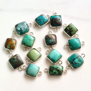 May include: A collection of turquoise gemstone connectors with silver-colored metal frames. The turquoise stones vary in color, ranging from vibrant teal to muted greens and browns. Each square stone is approximately 0.5 inches in size, with small loops on each side for connecting.