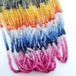 Könnte beinhalten: Stränge bunter Edelsteinperlen in einem Farbverlauf von Rosa, Blau, Gelb und Grün. Die kleinen, runden Perlen sind aufgefädelt und erzeugen einen Kaskadeneffekt. Geeignet für die Schmuckherstellung.