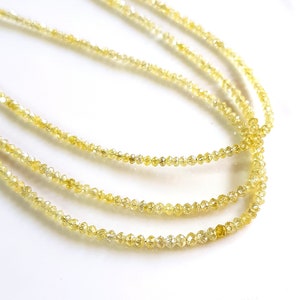 May include: A strand of yellow diamond beads. The beads are small and round, and they are strung together on a thin wire.