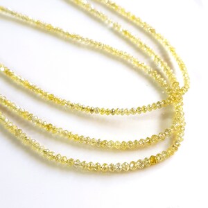 May include: A strand of yellow diamond beads. The beads are small and round, and they are strung together on a thin wire.