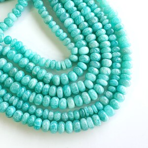 Puede incluir: Una hebra de cuentas de piedras preciosas de color verde turquesa, con un acabado liso y pulido. Las cuentas son redondas y ligeramente alargadas, creando un aspecto &uacute;nico y elegante.
